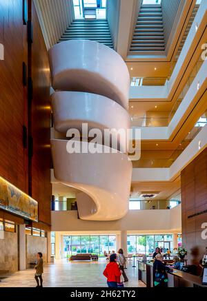 Das große Atrium mit Oberlichtern und einer dramatischen Wendeltreppe im Museum of American Arts & Crafts Movement in St. Petersburg, Florida, USA Stockfoto