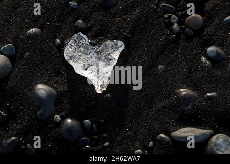 Herzförmiges Eisstück am schwarzen Strand, Küstenabschnitt in der Nähe der jokulsarlon-Gletscherlagune, vatnajokull-Nationalpark, island Stockfoto