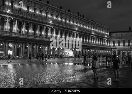 Fantastische Nacht auf dem markusplatz mit dem campanile und der Basilika des heiligen Markus. Bunte abendliche Stadtansicht von venedig, italien, europa mit viel reflektierendem Wasser. Stockfoto