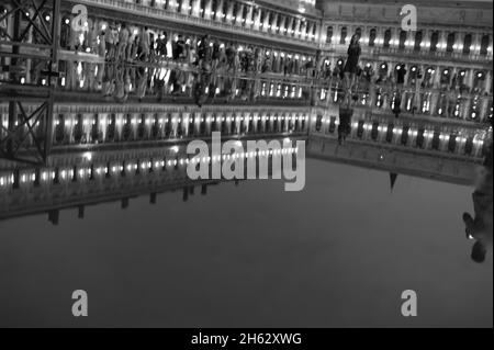 Fantastische Nacht auf dem markusplatz mit dem campanile und der Basilika des heiligen Markus. Bunte abendliche Stadtansicht von venedig, italien, europa mit viel reflektierendem Wasser. Stockfoto