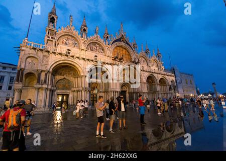 Fantastische Nacht auf dem markusplatz mit dem campanile und der Basilika des heiligen Markus. Bunte abendliche Stadtansicht von venedig, italien, europa mit viel reflektierendem Wasser. Stockfoto