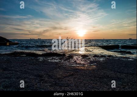 Planschende Welle an der kroatischen Küste während des Sonnenuntergangs Stockfoto