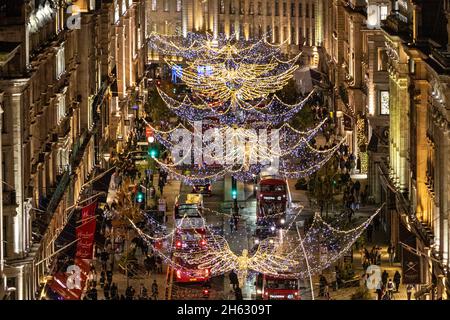 Regent Street, London, Großbritannien. November 2021. Ein Blick aus der Vogelperspektive auf die Regent Street Christmas Lights, von einem Dach des Oxford Circus während des Schalters an diesem Abend. Die traditionellen ‘Spirit of Christmas'-Lichter, die große Engel zeigen, die ihre Flügel über die Straße ausbreiten, werden entlang der Regent Street vom Oxford Circus und durch das Viertel St. James's installiert. Die Lichter sind hier von oben zu sehen, in Aufnahmen aus einem Gebäude auf der Regent Street und dem Oxford Circus. Kredit: Imageplotter/Alamy Live Nachrichten Stockfoto