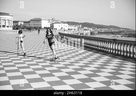 Skater Mädchen Skaten und Springen auf terrazza mascagni in livorno, italien. Es ist ein breites gewundenes belvedere zum Meer mit einer Pflasterfläche von 8700 qm wie ein Schachbrett und 4,100 Balustern Stockfoto