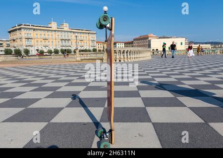 Ein Skateboard auf terrazza mascagni in livorno, italien. Es ist ein breites, gewundenes belvedere zum Meer hin mit einer Pflasterfläche von 8700 qm wie ein Schachbrett und 4,100 Balustern Stockfoto