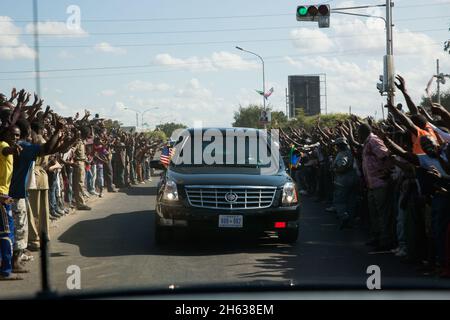 Die Menschen säumen die Straße, als Präsident Barack Obamas Autokolonne zum State House in dar es Salaam, Tansania, 1. Juli 2013 auffährt. Stockfoto