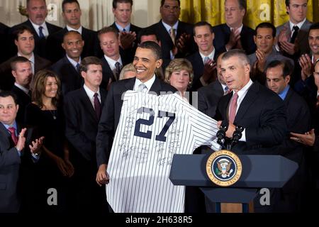 Joe Girardi, Manager der New Yorker Yankees, überreicht Präsident Barack Obama bei einer Zeremonie im East Room des Weißen Hauses ein signiertes Mannschaftstrikot zu Ehren der Weltmeister aus dem Jahr 2009. Stockfoto