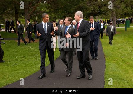 Präsident Barack Obama spricht mit dem russischen Präsidenten Dmitri Medwedew und dem kanadischen Premierminister Stephen Harper, während sie nach dem Familienfoto beim Gipfel G8 in Muskoka, Kanada, am 25. Juni 2010 mit anderen Führern zusammen gehen. Stockfoto