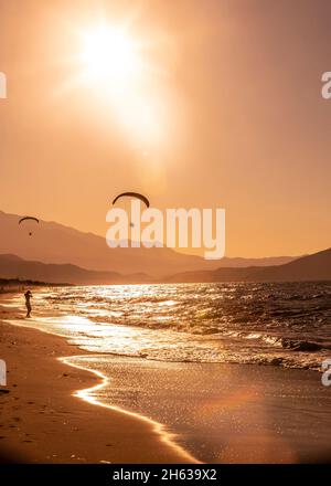 Menschen am Strand in Bewegung bei Sonnenuntergang Stockfoto