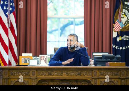 Präsident Barack Obama telefoniert am Thanksgiving Day vom Oval Office zu US-Truppen, die weltweit stationiert sind, am 24. November 2016. Stockfoto