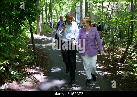Präsident Barack Obama spricht mit Bundeskanzlerin Angela Merkel, die während des Gipfeltreffens G8 in Camp David, MD., 19. Mai 2012 von Laurel Cabin zur Aspen Cabin geht. Stockfoto
