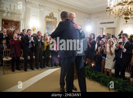 Vizepräsident Joe Biden umarmt Präsident Barack Obama, nachdem er am 12. Januar 2017 im Staatlichen Speisesaal des Weißen Hauses die Presidential Medal of Freedom mit Auszeichnung erhalten hatte. Stockfoto