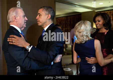 Präsident Barack Obama und First Lady Michelle Obama begrüßen Vizepräsident Joe Biden und Dr. Jill Biden kurz nachdem die Fernsehsender die Wahl zu ihren Gunsten anriefen, während sie die Wahlwiederkehr im Fairmont Chicago Millennium Park in Chicago, Illinois, am 6. November 2012 beobachten. Stockfoto