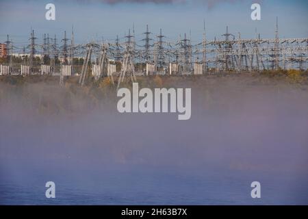 russland, sibirien, bratsk, Wasserkraftwerk angara Fluss, Nebel und Umspannwerk mit Strommasten Stockfoto