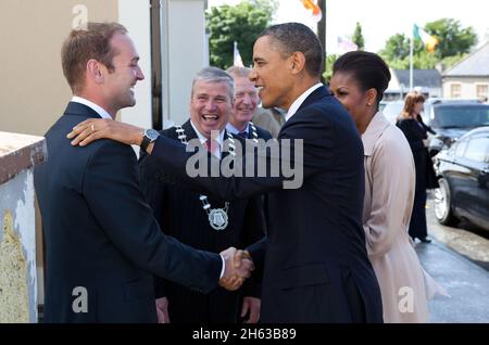 Präsident Barack Obama und First Lady Michelle Obama begrüßen Henry Healy, den Cousin des Präsidenten, nachdem er am 23. Mai 2011 in Moneygall, Irland, angekommen war. Der Präsident und die First Lady wurden auch von Counselor Danny Owens, Vorsitzender von Offaly County, und Counselor John Kennedy, Vorsitzender von Tipperary County, Mitte, begrüßt. Stockfoto