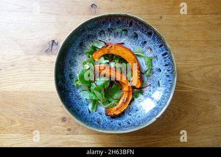 Kürbis mit Salat auf dem Teller Stockfoto