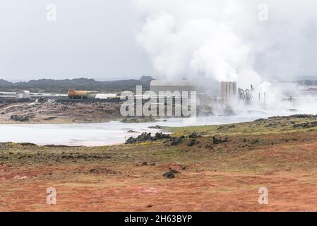 Geothermisches Kraftwerk, das an einem nebligen Tag in einer Vulkanlandschaft in Island mit Dampf umhüllt ist Stockfoto