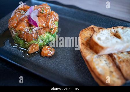 Lachs- und Avocado-Tartar-Gericht in der Brasserie Ctretze Pirineus, EINEM Brauerei-RESTAURANT IM Dorf Pobla de Segur und im nördlichen Teil des Sa Stockfoto