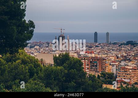 Blick auf die Innenstadt von barcelona aus antoni gaudis künstlerischem Park guell in barcelona, spanien. Dieser modernistische Park wurde zwischen 1900 und 1914 erbaut und ist eine beliebte Touristenattraktion. Stockfoto