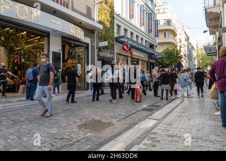 Athen, Griechenland. 2021. November. Menschen, die in der zentralen Ermou-Straße zum Einkaufen bummeln Stockfoto