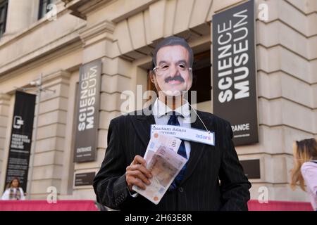 London, Großbritannien. November 2021. Ein Protestler, der als Adani-Vorsitzender Gautam Adani gekleidet ist, posiert während der Demonstration mit gefälschtem Geld.Aktivisten des Extinction Rebellion veranstalteten einen Protest gegenüber dem Science Museum in South Kensington gegen das Sponsoring des Museums durch die fossilen Energiekonzerne Shell und Adani. Kredit: SOPA Images Limited/Alamy Live Nachrichten Stockfoto