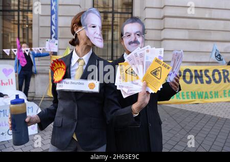 London, Großbritannien. November 2021. Demonstranten, die als Adani-Vorsitzender Gautam Adani und Shell-CEO Ben van Beurden gekleidet sind, posieren während der Demonstration mit gefälschtem Geld.Aktivisten des Extinction Rebellion protestierten gegenüber dem Science Museum in South Kensington gegen die Sponsoring des Museums durch die fossilen Energiekonzerne Shell und Adani. Kredit: SOPA Images Limited/Alamy Live Nachrichten Stockfoto