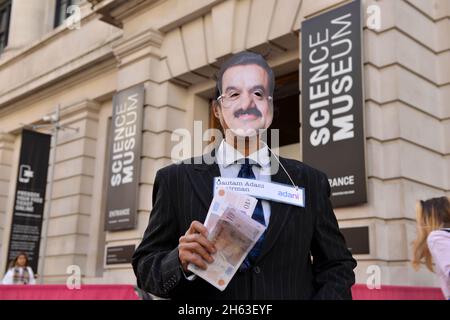 London, Großbritannien. November 2021. Ein Protestler, der als Adani-Vorsitzender Gautam Adani gekleidet ist, posiert während der Demonstration mit gefälschtem Geld.Aktivisten des Extinction Rebellion veranstalteten einen Protest gegenüber dem Science Museum in South Kensington gegen das Sponsoring des Museums durch die fossilen Energiekonzerne Shell und Adani. (Foto von Thomas Krych/SOPA Images/Sipa USA) Quelle: SIPA USA/Alamy Live News Stockfoto