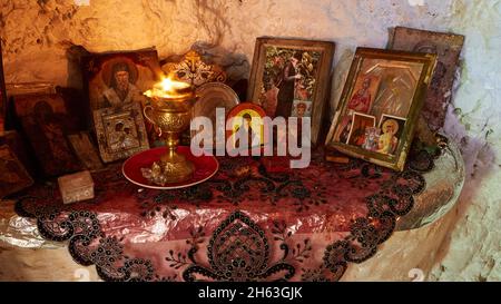 griechenland, griechische Inseln, ionische Inseln, kefalonia, in der Nähe von argostoli, Lassi, Höhlenkirche von agios gerasimos, Einsiedlerhöhle, Ikonen, Kerzenständer mit brennenden Kerzen in einer Felsennische Stockfoto