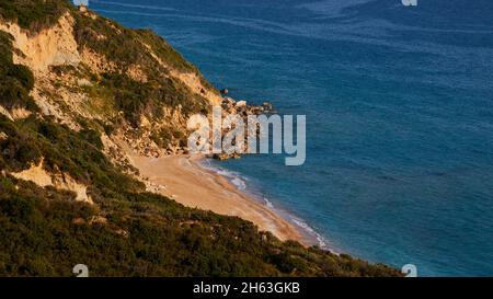 griechenland, griechische Inseln, ionische Inseln, kefalonia, Südostküste, korona Strand, kleiner Sandstrand, felsige Küste, grünes bergiges Hinterland, Felsen im Wasser, grünes Meer, blaues Meer Stockfoto