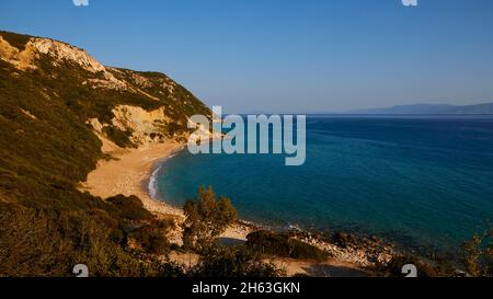 griechenland, griechische Inseln, ionische Inseln, kefalonia, Südostküste, korona Strand, kleiner Sandstrand, felsige Küste, grünes bergiges Hinterland, Felsen im Wasser, grünes Meer, blaues Meer Stockfoto