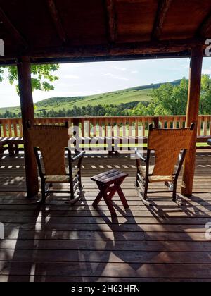 Eine Aussicht, amerikanischer Westen, Dude Ranch, Freizeit, Veranda, entspannend, Schaukelstühle, Schatten, Sonnenschein, usa, wyoming, Bighorn Berge, eaton Ranch, Veranda, Holzstühle auf Holz Veranda, Holz Terrasse Stockfoto