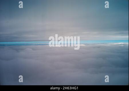 Der Blick durch die Wolken aus einem Flugzeug Stockfoto