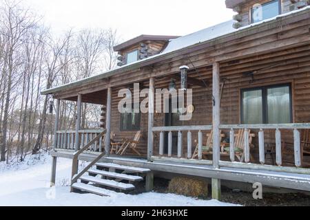 Eine Holzhütte liegt zusammen mit Schnee in Upstate New York Stockfoto