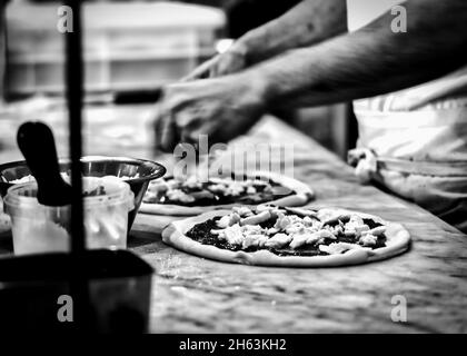 Ein Koch, der in einer Pizzeria in Kamakura, Japan, Pizza für den Holzofen zubereitet. Stockfoto