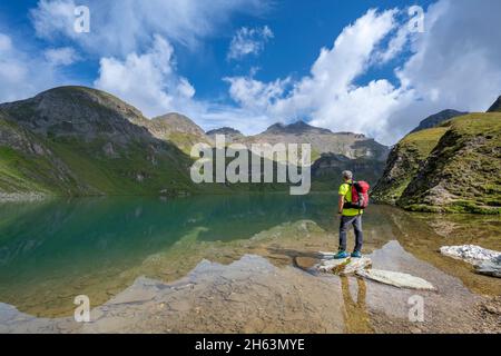 vals,mühlbach,provinz bozen,Südtirol,italien. Ein Bergwanderer auf der wilderen See,hinter dem Gipfel der wilderen kreuzspitze Stockfoto