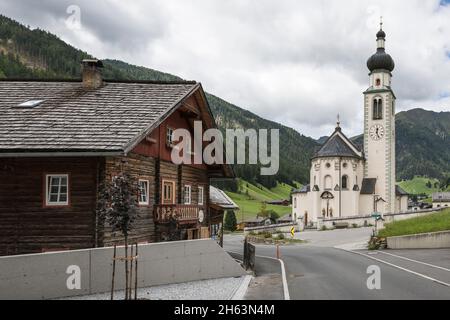 innervillgraten im villgratental, Holzhaus mit Blick auf die Pfarrkirche St. martin, osttirol, lienz, tirol, österreich Stockfoto