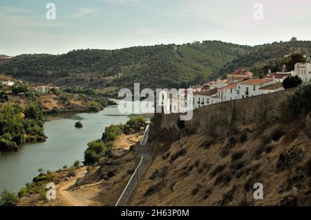 Die Burgmauern der Stadt Mertola und der Fluss Guadiana am Nachmittag. Mertola, Alentejo, Portugal Stockfoto