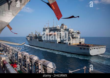 GOLF VON OMAN (NOV 11, 2021) Trocken- und Munitionsschiff USNS Cesar Chavez (T-AKE 14) bereitet sich darauf vor, während eines Wiederauffüllens auf See am 11. November an der Seite des amphibischen Angriffsschiffes USS Essex (LHD 2) zu fahren. Essex und die 11. Marine Expeditionary Unit werden im Einsatzgebiet der 5. US-Flotte eingesetzt, um Marineoperationen zu unterstützen, um die maritime Stabilität und Sicherheit in der Zentralregion zu gewährleisten und das Mittelmeer und den Pazifik durch den westlichen Indischen Ozean und drei strategische Engpässe zu verbinden. (USA Navy Foto von Mass Communication Specialist 2nd Class John McGovern) Stockfoto