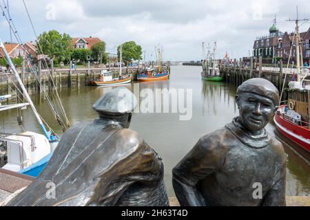 deutschland, niedersachsen, ostfriesland, neuharlingersiel im Fischereihafen. Alte und junge Fischer vom Bildhauer hans-christian petersen. Stockfoto