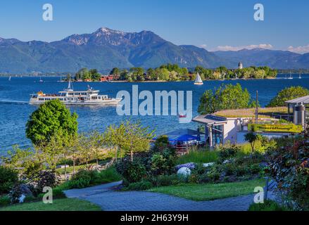 Ausflugsboot vor Gartenanlage am Seeufer Richtung fraueninsel und hochgern (1748m),gstadt,chiemsee,chiemgau,oberbayern,bayern,deutschland Stockfoto