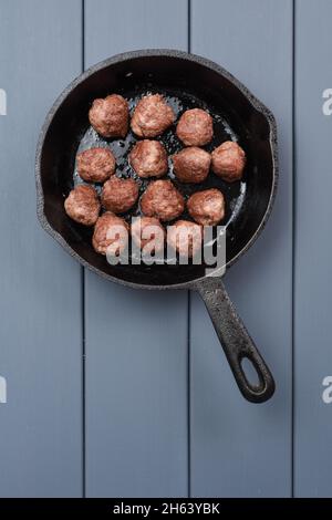 Fleischbällchen aus Rindfleisch, zubereitet in einer gusseisernen Pfanne auf grauem Hintergrund, Copyspace über der Ansicht mit Copyspace Stockfoto