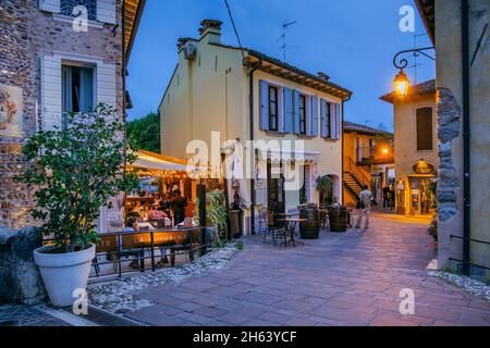 Gasse mit Restaurants im historischen Dorf in der Abenddämmerung,borghetto,Bezirk valeggio sul mincio,Mühlendorf,po plain,Provinz verona,venetien,italien Stockfoto