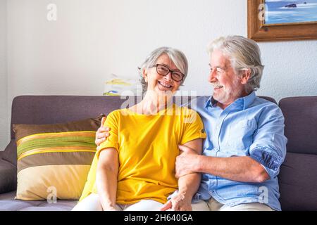 Porträt von zwei glücklichen und gesunden Senioren, alte Menschen, die lächeln und die Kamera betrachten. Nahaufnahme von erwachsenen Großeltern, die gemeinsam zu Hause drinnen Spaß haben. Stockfoto