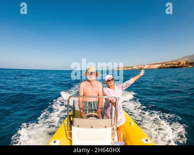 Schöne und niedliche paar Senioren oder alte Menschen in der Mitte des Meeres fahren und entdecken Sie neue Orte mit kleinen Boot. Reife Frau hält ein Telefon und ein Selfie mit HEW Ehemann Stockfoto