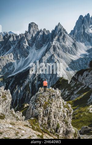 Der Wanderer steht und bewundert die atemberaubende Schönheit der beeindruckenden zerklüfteten Gipfel der cadini di misurina-Berggruppe in den dolomiten, italien, Teil des Nationalparks Tre cime di Levaredo. Stockfoto