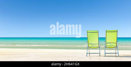 Liegestühle am Strand mit blauem Meer Stockfoto