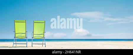 Liegestühle am Strand mit blauem Meer Stockfoto