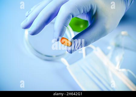 Die Hand des Arztes in einem Handschuh enthält Omega-3-Vitamine. Fischöl. Medizinisches Konzept. Stockfoto