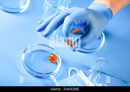 Die Hand des Arztes in einem Handschuh enthält Omega-3-Vitamine. Fischöl. Medizinisches Konzept. Stockfoto