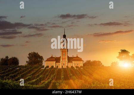 Die Sonne geht hinter der Basilika birnaus auf Stockfoto